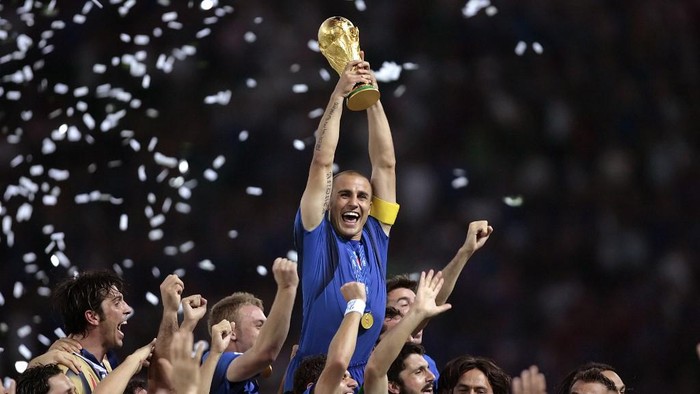 Italian defender Fabio Cannavaro (C) celebrates with the trophy after the World Cup 2006 final football game Italy vs.France, 09 July 2006 at Berlin stadium. Italy won the 2006 football World Cup by defeating France on penalties. AFP PHOTO PASCAL PAVANI (Photo by PASCAL PAVANI / AFP)