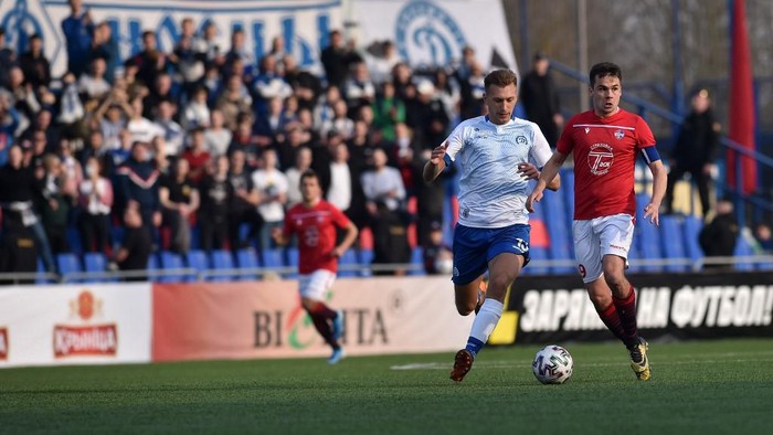FC Minsk and FC Dinamo-Minsk team players vie for the ball during the Belarus Championship football match in Minsk, on March 28, 2020. - Belarus continue its championship despite all the leagues in Europe cancelled it to curb the spread of the COVID-19, the novel coronavirus. (Photo by Sergei GAPON / AFP)