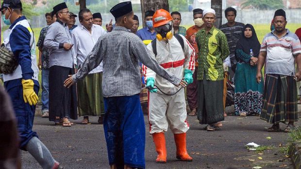 Petugas menyemprotkan cairan disinfektan kepada santri yang baru datang di Kabupaten Pekalongan, Jawa Tengah, Selasa (31/3/2020). Pemerintah setempat melakukan cek suhu badan dan penyemprotan cairan disinfektan kepada rombongan 15 bus berisi sekitar 800 orang santri asal Kabupaten Pekalongan yang pulang dari Pondok Pesantren (Ponpes) Api Tegal Rejo Magelang dan Ponpes Lir Boyo Kediri untuk mencegah penyebaran wabah virus Corona (COVID-19). ANTARA FOTO/Harviyan Perdana Putra/wsj.