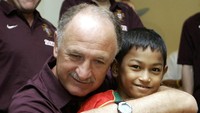 Luiz Felipe Scolari, saat itu melatih timnas Portugal, tak kuasa menahan diri untuk memeluk Martunis yang sudah selamat dari bencana alam mematikan. (Foto: AFP/FRANCISCO PARAISO)
