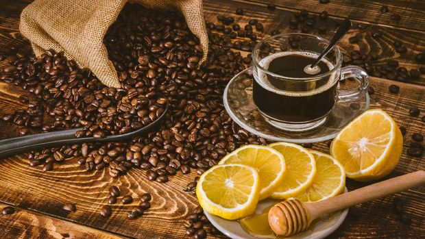 Kopi Lemon Coffee cup and beans on old kitchen table. Top view with copy space for your text. coffee bag and with sliced