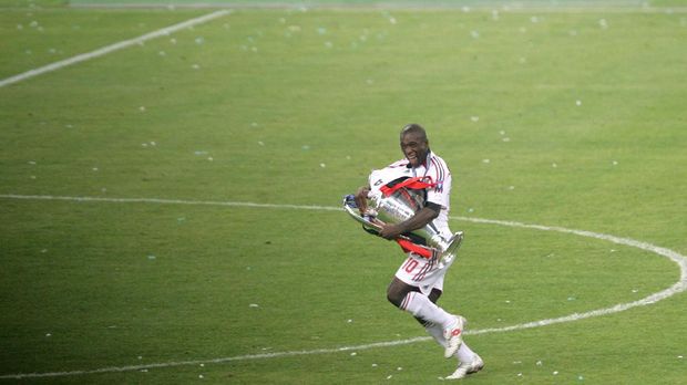 AC Milan's Dutch midfielder Clarence Seedorf runs with the trophy after winning  the Champions League final football match, at the Olympic Stadium, in Athens, 23 May 2007.  AFP PHOTO / ARIS MESSINIS (Photo by ARIS MESSINIS / AFP)