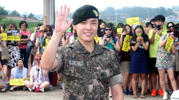 This photo taken on August 8, 2013 shows South Korean singer Wheesung (C) waving as fans look on, at his military service discharge ceremony in Nonsan. The 31-year-old singer enlisted for mandatory military service in 2011.    REPUBLIC OF KOREA OUT      JAPAN OUT       AFP PHOTO/STARNEWS (Photo by Starnews / Starnews / AFP)