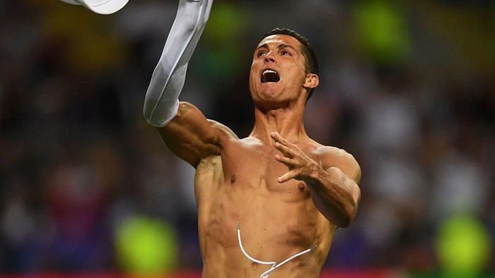 MILAN, ITALY - MAY 28:  Cristiano Ronaldo of Real Madrid takes off his shirt in celebration after scoring the winning penalty in the penalty shoot out during the UEFA Champions League Final match between Real Madrid and Club Atletico de Madrid at Stadio Giuseppe Meazza on May 28, 2016 in Milan, Italy.  (Photo by Laurence Griffiths/Getty Images)