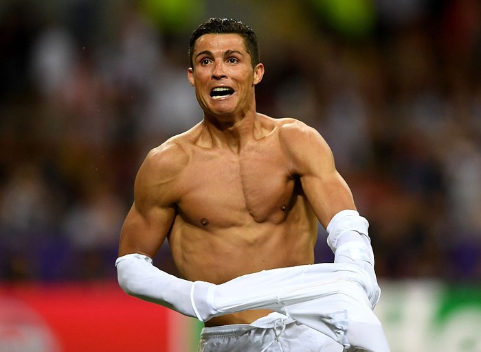 MILAN, ITALY - MAY 28:  Cristiano Ronaldo of Real Madrid takes off his shirt in celebration after scoring the winning penalty in the penalty shoot out during the UEFA Champions League Final match between Real Madrid and Club Atletico de Madrid at Stadio Giuseppe Meazza on May 28, 2016 in Milan, Italy.  (Photo by Laurence Griffiths/Getty Images)