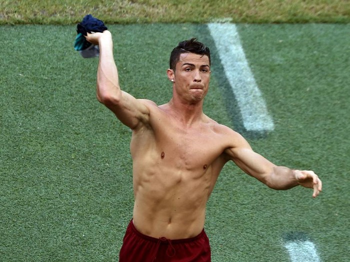 Portugal's forward and captain Cristiano Ronaldo throws his shirt to the fans prior to the Group G football match between Germany and Portugal at the Fonte Nova Arena in Salvador during the 2014 FIFA World Cup on June 16, 2014. AFP PHOTO / DIMITAR DILKOFF (Photo by DIMITAR DILKOFF / AFP)