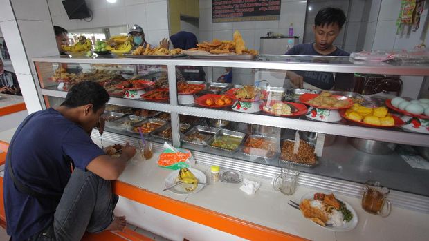 Warga makan di Warteg Subsidi Bahari kawasan Jalan Fatmawati, Jakarta, Sabtu (28/3/2020). Program Operasi Makan Gratis bersama sejumlah Warung Tegal (Warteg) di wilayah Jakarta, Bogor, Depok, Tangerang dan Bekasi diharapkan bisa membantu persoalan pendapatan para pemilik warteg dan pekerja harian yang terdampak wabah Virus Corona (COVID-19).  ANTARA FOTO/Reno Esnir/ama. *** Local Caption ***
