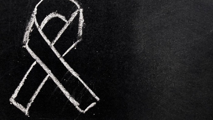 White chalk drawing as black ribbon shape on black board background (Concept for symbol of remembrance or mourning)