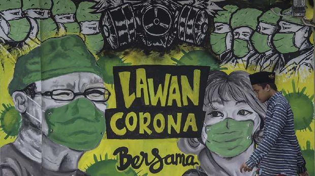 A man walks past a mural depicting the COVID-19 coronavirus in Bangkalan, east Java on April 6, 2020. (Photo by Juni Kriswanto / AFP) / ìThe erroneous mention[s] appearing in the metadata of this photo by Juni Kriswanto has been modified in AFP systems in the following manner: [Bangkalan] instead of [Surabaya]. Please immediately remove the erroneous mention[s] from all your online services and delete it (them) from your servers. If you have been authorized by AFP to distribute it (them) to third parties, please ensure that the same actions are carried out by them. Failure to promptly comply with these instructions will entail liability on your part for any continued or post notification usage. Therefore we thank you very much for all your attention and prompt action. We are sorry for the inconvenience this notification may cause and remain at your disposal for any further information you may require.î