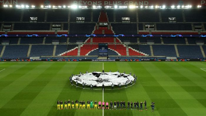 Liga Champions PARIS, FRANCE - MARCH 11: (FREE FOR EDITORIAL USE) In this handout image provided by UEFA, General view inside the empty stadium as the two teams line up prior to the UEFA Champions League round of 16 second leg match between Paris Saint-Germain and Borussia Dortmund at Parc des Princes on March 11, 2020 in Paris, France. The match is played behind closed doors as a precaution against the spread of COVID-19 (Coronavirus). (Photo by UEFA - Handout/UEFA via Getty Images)