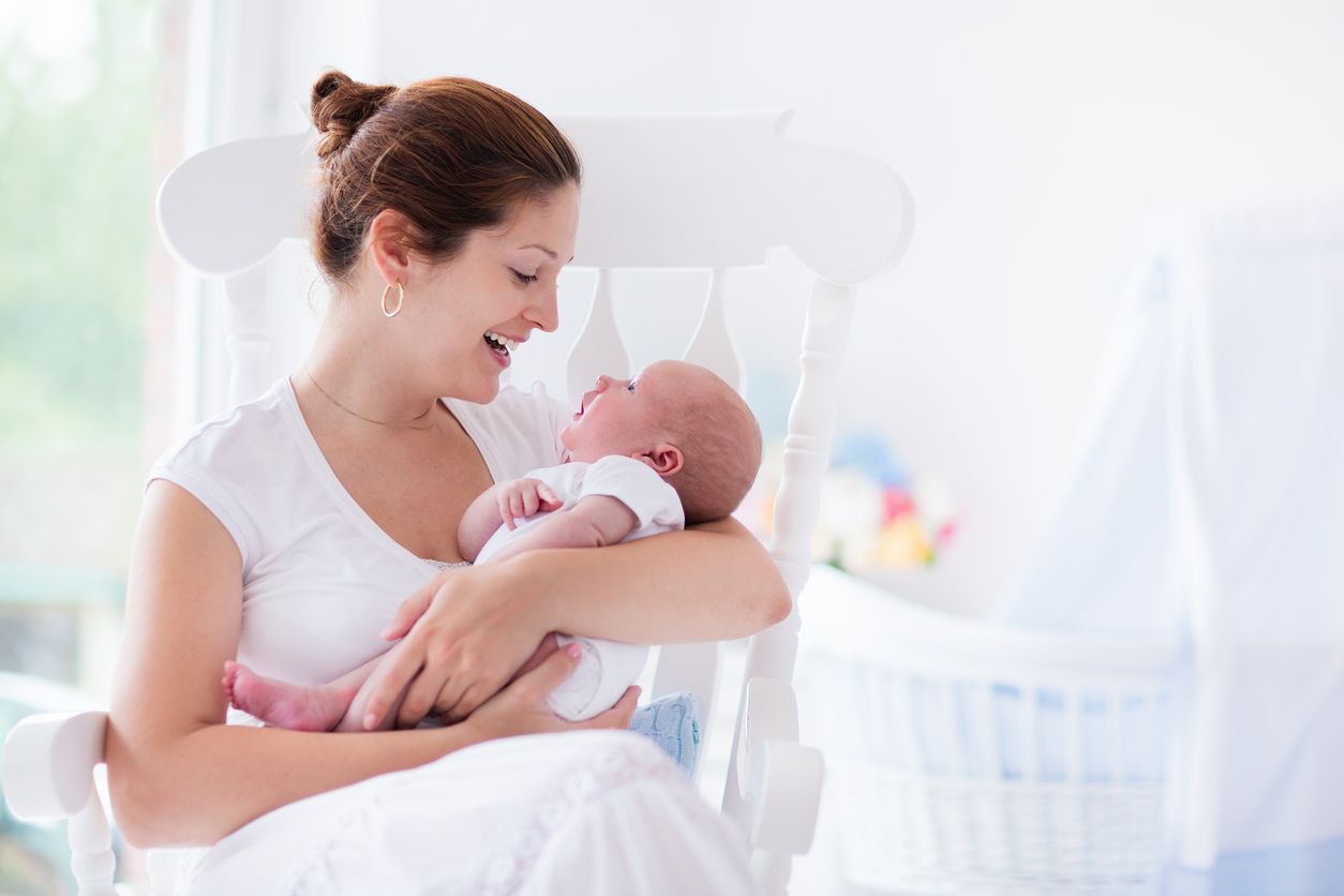 Mother breastfeeding baby son in bedroom, they enjoy in this moment together