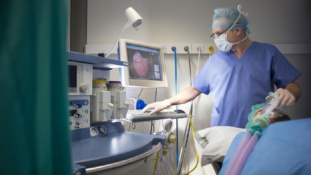 Anesthetist with patient , the patient is the one lying down , and the anaesthetist is the one standing up .