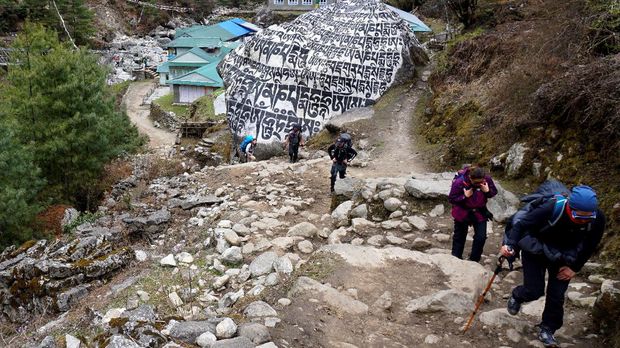 Everest Sepi Terdampak Pandemi Corona Trekkers and their guide make their way along a path in Phakding on March 23, 2020, after Nepal suspended mountain expeditions and trekking as a preventive measure against the COVID-19 novel coronavirus. (Photo by Prakash MATHEMA / AFP)