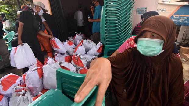 Petugas dibantu warga menurunkan paket sembako yang diberikan Kementerian Sosial (Kemensos) kepada warga yang membutuhkan di kawasan Kebon Baru, Tebet, Jakarta, Rabu (8/4/2020). Kemensos mendistribusikan 200 ribu paket sembako dan makanan siap saji untuk pekerja sektor informal di wilayah zona merah COVID-19. ANTARA FOTO/Indrianto Eko Suwarso/foc.