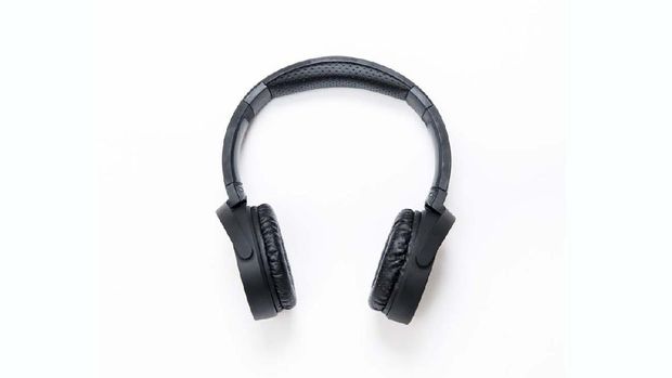 High angle view of a black wireless headphone over isolated on white. These headphones are wireless and work through bluetooth. Vertical composition. Image taken with Nikon D800 and developed from Raw format.