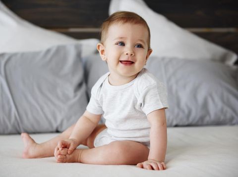 Portrait of confused baby lying on the bed