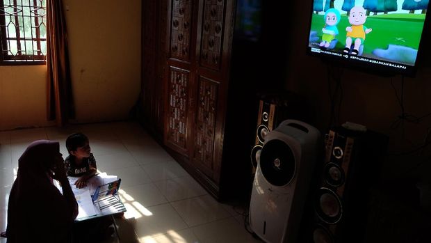 Seorang anak didampingi ibunya belajar dengan melihat tayangan siaran TVRI di rumah mereka, di Deli Serdang, Sumatera Utara, Senin (13/4/2020). Kementerian Pendidikan dan Kebudayaan bekerja sama dengan lembaga penyiaran publik TVRI sejak Senin (13/4) hingga tiga bulan ke depan menyiarkan program belajar bagi siswa mulai dari tingkat pendidikan anak usia dini (PAUD) hingga SMA guna membantu para siswa belajar di rumah selama wabah COVID-19. ANTARA FOTO/Irsan Mulyadi/hp.