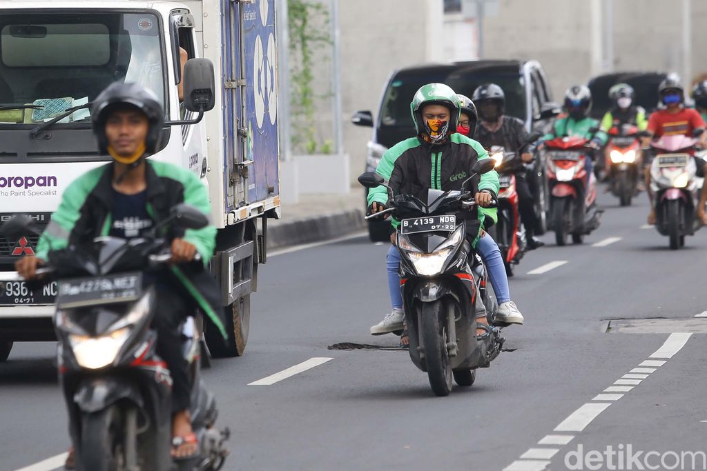 Ojek online kembali tengah menarik penumpang di kawasan Jakarta Selatan, Senin (13/4/2020). Kementerian Perhubungan mengizinkan ojek online (ojol) untuk kembali mengangkut penumpang wilayah yang menerapkan PSBB.