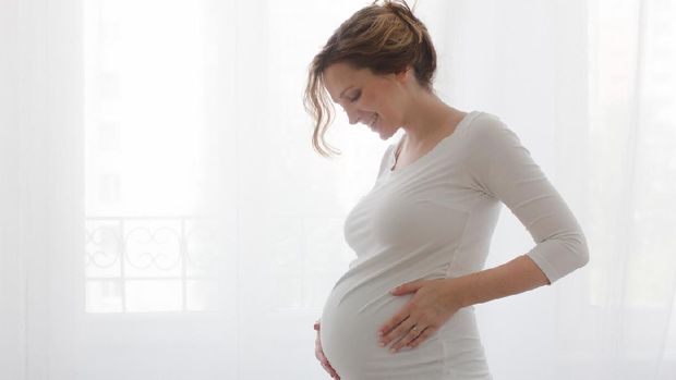 beauty pregnant woman smile and think something at home
