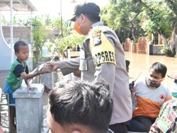 Polisi Pasuruan Kota Bagikan Nasi Bungkus Korban Banjir dengan Naik Perahu