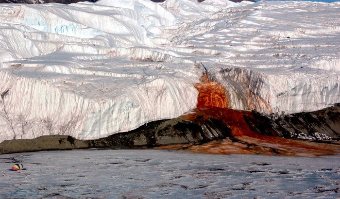 Air Terjun Darah di Antartika juga menjadi salah satu destinasi wisata populer bagi pencinta wisata horor dan misterius. Warna air yang berwarna merah seperti darah jadi salah satu daya tarik bagi para wisatawan untuk datang berkunjung dan melihat langsung air terjun tersebut. Istimewa/Dok. Wikipedia/National Science Foundation/Peter Rejcek.