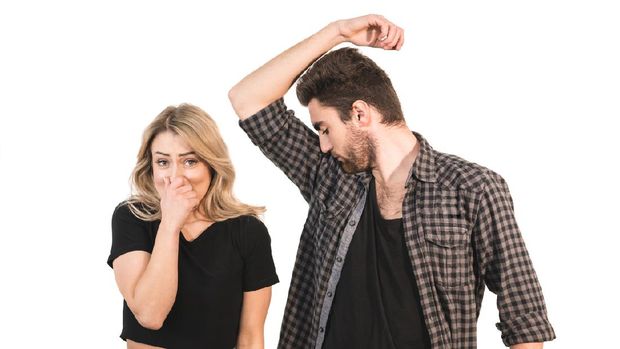 The man smells armpits near the woman on the white background