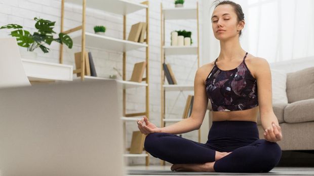 Self learning. Woman using laptop to training yoga online in living room