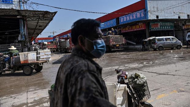 This photo taken on April 15, 2020 shows a man wearing a face mask while walking at the Wuhan Baishazhou Market in Wuhan in China's central Hubei province. - China's