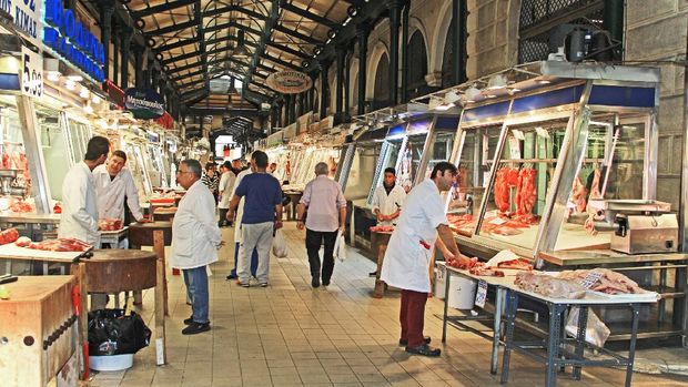 Athens, Attica, Greece – October 17, 2018:  Shoppers and owners along a large hall in the huge  covered Athens Central Public Market, Dimotiki Agora Meat and Fish Market or Varvakios Agora on Athinas Street, Athens, Greece.