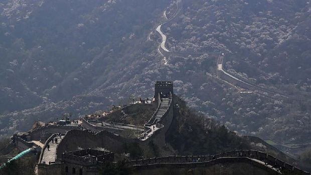 Visitors walk on a stretch of the Badaling Great Wall of China after it reopened weeks ago in Beijing, Tuesday, April 14, 2020. China reported dozens of new virus cases on Tuesday, most of them among travelers arriving from abroad, but no new deaths. (AP Photo/Andy Wong)