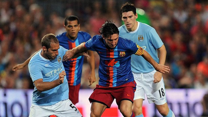 BARCELONA, SPAIN - AUGUST 19:  Lionel Messi (C) of Barcelona duels for the ball with Pablo Zabaleta (L) and Gareth Barry of Manchester City during the Joan Gamper Trophy match between Barcelona and Manchester City at the Camp Nou Stadium on August 19, 2009 in Barcelona, Spain. Manchester City won the match 1-0.  (Photo by Jasper Juinen/Getty Images)