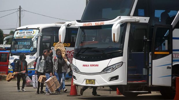 Sejumlah warga membawa barang bawaan menuju bis antar provinsi untuk mudik lebih awal di Terminal Bis Pakupatan, Serang, Banten, Kamis (23/4/2020). Meski pemerintah melarang mudik lebaran tahun 2020, sejumlah warga tetap pulang ke kampung halamannya sebelum puasa dengan alasan sudah tidak ada pekerjaan meski nantinya harus menjalani isolasi mandiri.  ANTARA FOTO/Asep Fathulrahman/nz