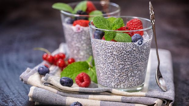 Two glasses of chia seed pudding with fresh berry fruits and mint topping for the breakfast