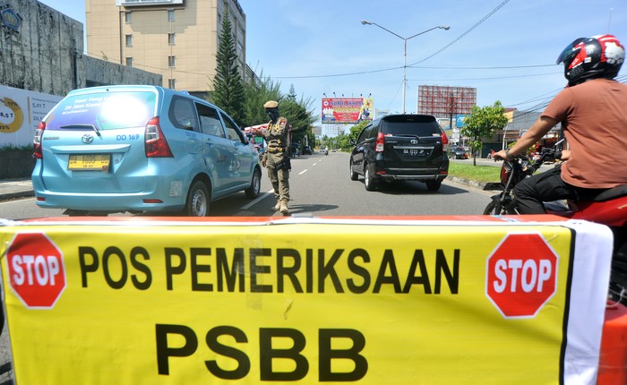 Petugas memeriksa penumpang di dalam kendaraan yang melintas di Posko Check Point Pembatasan Sosial Berskala Besar (PSBB) di Air Tawar, Padang, Sumatera Barat, Rabu (22/4/2020). PSBB diterapkan di Padang dan kabupaten/ kota lain di provinsi itu mulai Rabu (22/4/2020) hingga 5 Mei 2020 untuk menghentikan penyebaran COVID-19, diantaranya dengan membatasi aktivitas di luar rumah, wajib menggunakan masker serta pembatasan jumlah penumpang kendaraan roda empat dan roda dua.