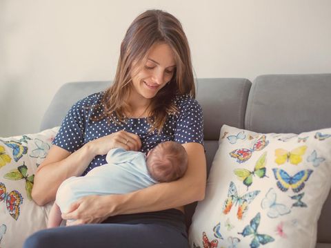 Mother breastfeeding a new born baby boy in a hospital room