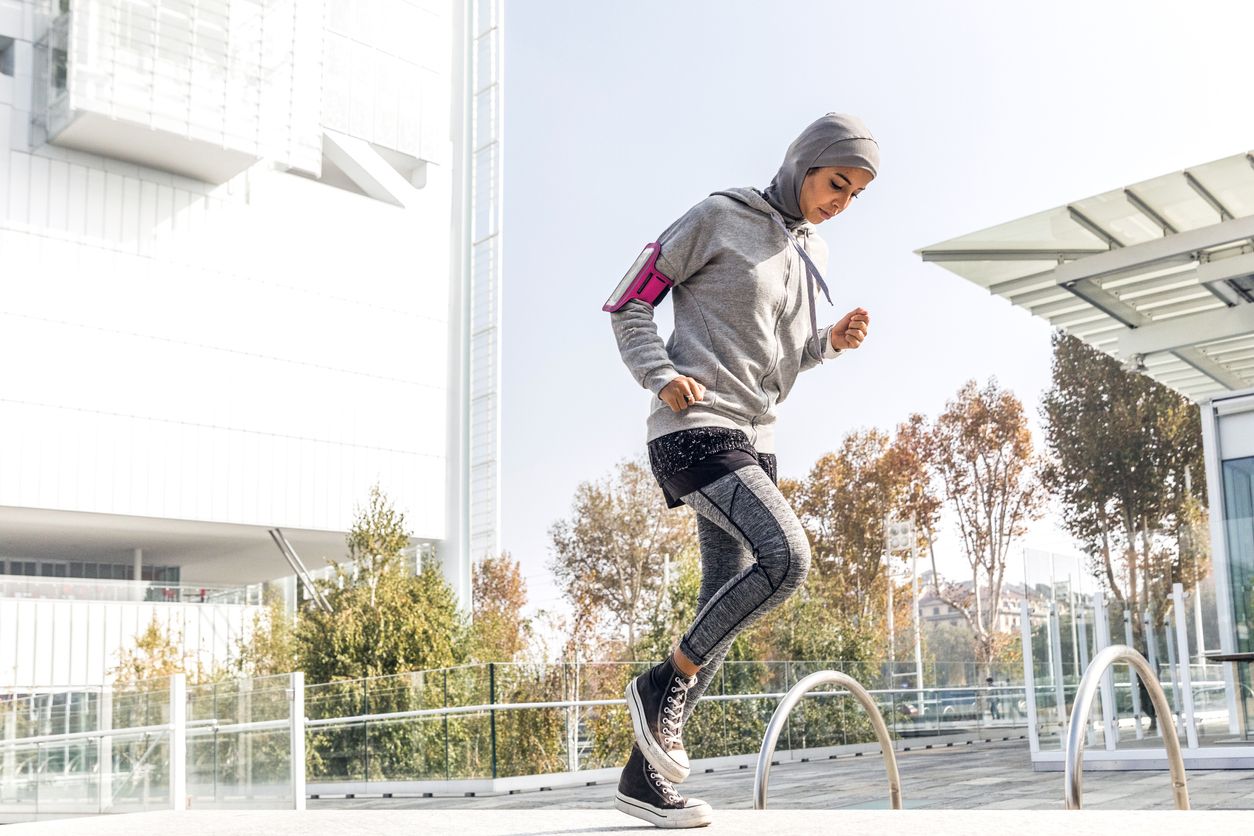 Athletic muslim woman is exercising on staircase