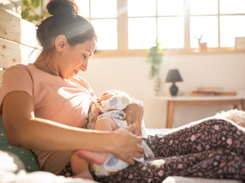 Mother breastfeeding a new born baby boy in a hospital room