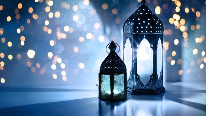 Ilustrasi Ramadhan Couple of glowing Moroccan ornamental lanterns on the table. Greeting card, invitation for Muslim holy month bulan puasa Kareem, festive blue night background with glittering golden bokeh lights.
