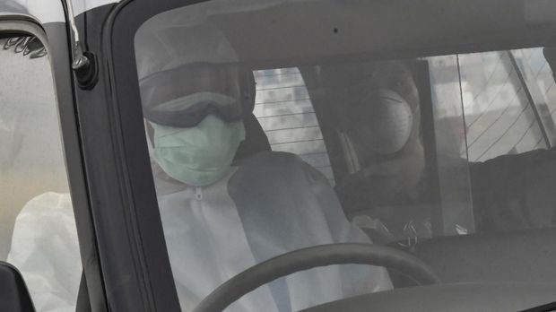 Warga Negara Indonesia (WNI), anak buah kapal Kapal Pesiar MV Arthania yang diduga positif COVID-19 (kanan) berada di dalam mobil ambulans di Pelabuhan JICT, Tanjung Priok, Jakarta, Jumat (24/4/2020). Sebanyak 56 WNI tersebut akan dibawa menuju RS Darurat COVID-19 Wisma Atlet Kemayoran untuk diobservasi. ANTARA FOTO/Muhammad Adimaja/wsj.