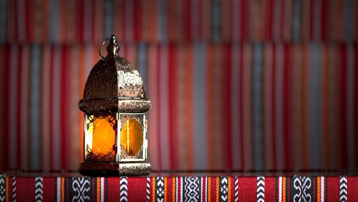Ilustrasi Ramadhan Couple of glowing Moroccan ornamental lanterns on the table. Greeting card, invitation for Muslim holy month bulan rahmat Kareem, festive blue night background with glittering golden bokeh lights.