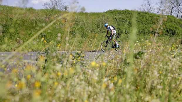 In this image taken on Tuesday, April 14, 2020, Italian professional cyclist Davide Martinelli, rides his bike after collecting medicine at a pharmacy to be delivered to residents in Rovato, near Brescia, Northern Italy. There are no fans lining the road. No teammates providing support. And no race to win. Professional cyclist Davide Martinelli has achieved a moral victory, though, by using his bike to help deliver medicine to elderly residents of his hometown in northern Italy during the coronavirus pandemic. (AP Photo/Luca Bruno)