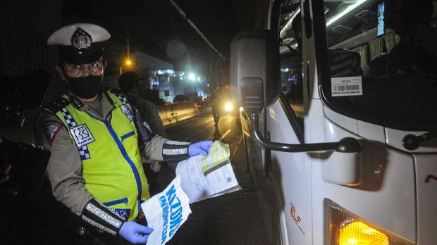 Polisi memeriksa surat ijin sopir mobil travel yang membawa tiga orang TKI ( Tenaga Kerja Indonesia ) dari luar negeri di tol Jakarta-Cikampek, Cikarang, Kabupaten Bekasi, Jawa Barat, Sabtu (25/4/2020). Pada hari kedua penyekatan pemudik di jalan tol masih banyak kendaraan yang tidak mengatur jarak sosial dan warga yang memaksaan untuk mudik. ANTARA FOTO/ Fakhri Hermansyah/pras.