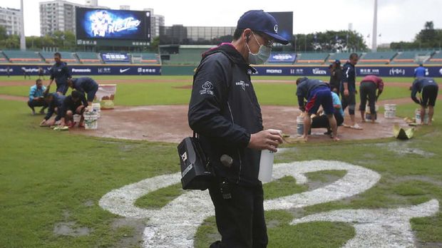 Petugas menyemprotkan disinfektan ke lapangan selama gelaran Liga Bisbol Taiwan. (