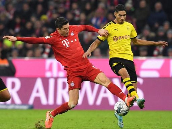 Bayern Munichs Polish striker Robert Lewandowski (L) and Dortmunds Moroccan defender Achraf Hakimi vie for the ball during the German first division Bundesliga football match FC Bayern Munich vs BVB Borussia Dortmund in Munich, southern Germany, on November 9, 2019. (Photo by Christof STACHE / AFP) / DFL REGULATIONS PROHIBIT ANY USE OF PHOTOGRAPHS AS IMAGE SEQUENCES AND/OR QUASI-VIDEO
