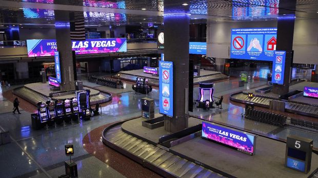 kosong dan sepi, cara las vegas bertahan hidup In this April 21, 2020, photo, electric signs that usually advertise casinos and other entertainment now give tips on preventing the spread of the coronavirus at McCarran International airport in Las Vegas. Nevada's governor shuttered the glitzy casinos and nightlife attractions of Las Vegas in mid-March, leaving much of the famous gambling mecca empty. (AP Photo/John Locher)