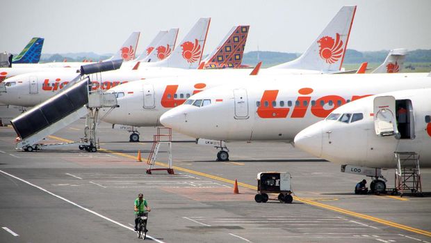 Petugas melintas di sejumlah pesawat yang terparkir di Terminal 1 Bandar Udara Internasional Juanda, Sidoarjo, Jawa Timur, Sabtu (25/4/2020). Kementerian Perhubungan menghentikan sementara aktivitas penerbangan komersil terjadwal baik dalam dan luar negeri untuk mencegah penyebaran virus corona (COVID-19) sebagai pengendalian transportasi selama masa mudik Lebaran 1441 H yang dimulai 24 April hingga 1 Juni 2020. ANTARA FOTO/Umarul Faruq/hp.