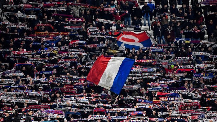 Lyons supporters wave flags and hold banners during the French Cup semi-final football match between Olympique Lyonnais (OL) and Paris Saint-Germain (PSG) at the Groupama Stadium in Decines-Charpieu, centraleastern France, on March 4, 2020. (Photo by Philippe DESMAZES / AFP)