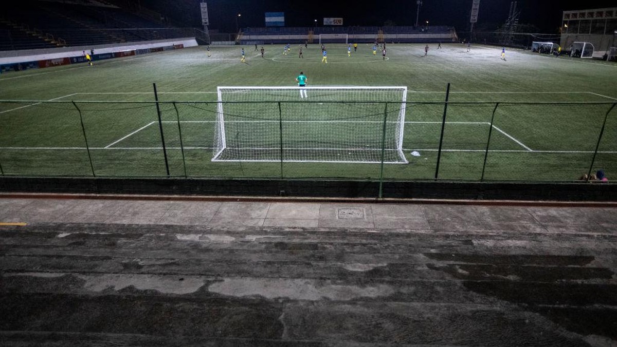 Laga Sepakbola Main Tertutup, eh Suporter Nonton dari Balik Pagar. (Foto: Inti Ocon/Getty Images)