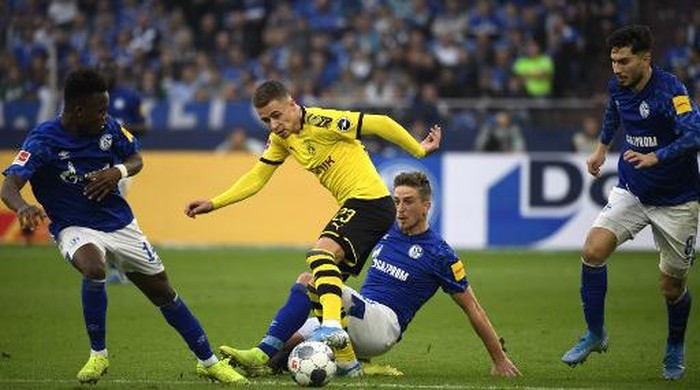 Schalkes German defender Bastian Oczipka and Dortmunds Belgian forward Thorgan Hazard (2nd L) vie for the ball during the German First division Bundesliga football match between Schalke 04 and Borussia Dortmund in Gelsenkirchen, on October 26, 2019. (Photo by INA FASSBENDER / AFP) / DFL REGULATIONS PROHIBIT ANY USE OF PHOTOGRAPHS AS IMAGE SEQUENCES AND/OR QUASI-VIDEO