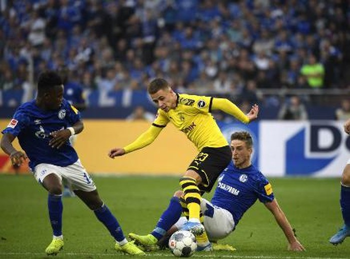 Schalkes German defender Bastian Oczipka and Dortmunds Belgian forward Thorgan Hazard (2nd L) vie for the ball during the German First division Bundesliga football match between Schalke 04 and Borussia Dortmund in Gelsenkirchen, on October 26, 2019. (Photo by INA FASSBENDER / AFP) / DFL REGULATIONS PROHIBIT ANY USE OF PHOTOGRAPHS AS IMAGE SEQUENCES AND/OR QUASI-VIDEO